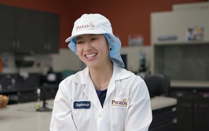 girl smiling with food safety clothes on