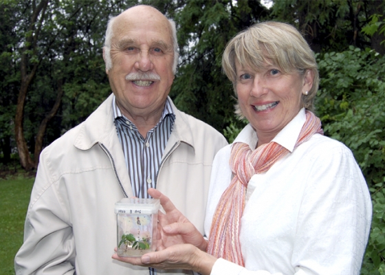 Two people holding a plant jar