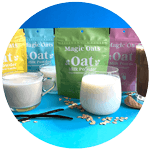 Colorful packages of Magic Oats oat milk powder displayed on a bright blue background, accompanied by glasses of oat milk, vanilla beans, and scattered oats.