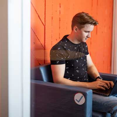 Person working on a laptop in a modern workspace, representing focus and technology for The AI Advantage webinar on career advancement.